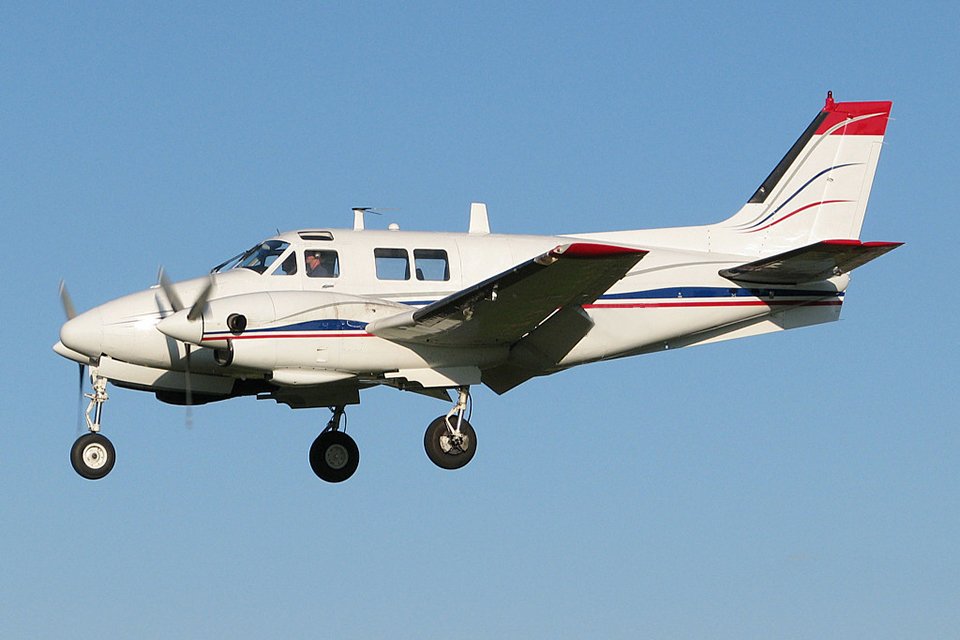 Beechcraft King Air 90 in flight with landing gear