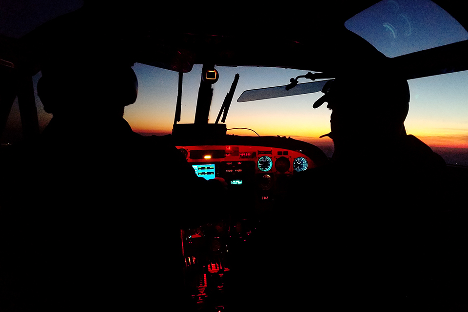 Pilots in the cockpit at sunset