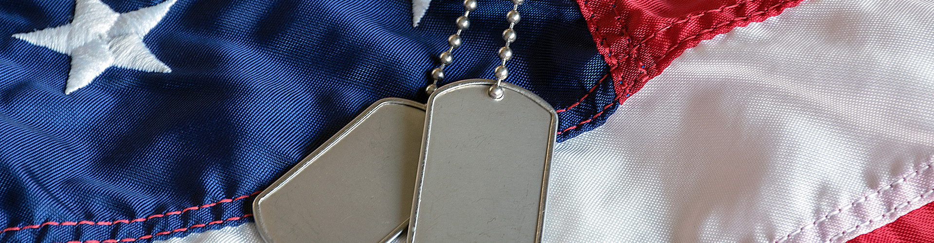 military dog tags on American flag with embroidered stars