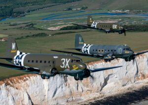 three c-47 warbirds flying in formation